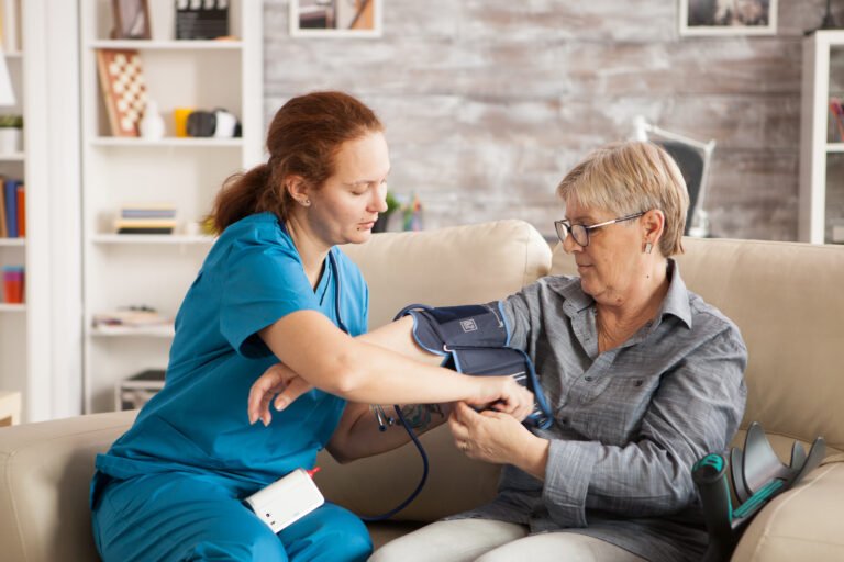 female nurse using digital blood pressure device